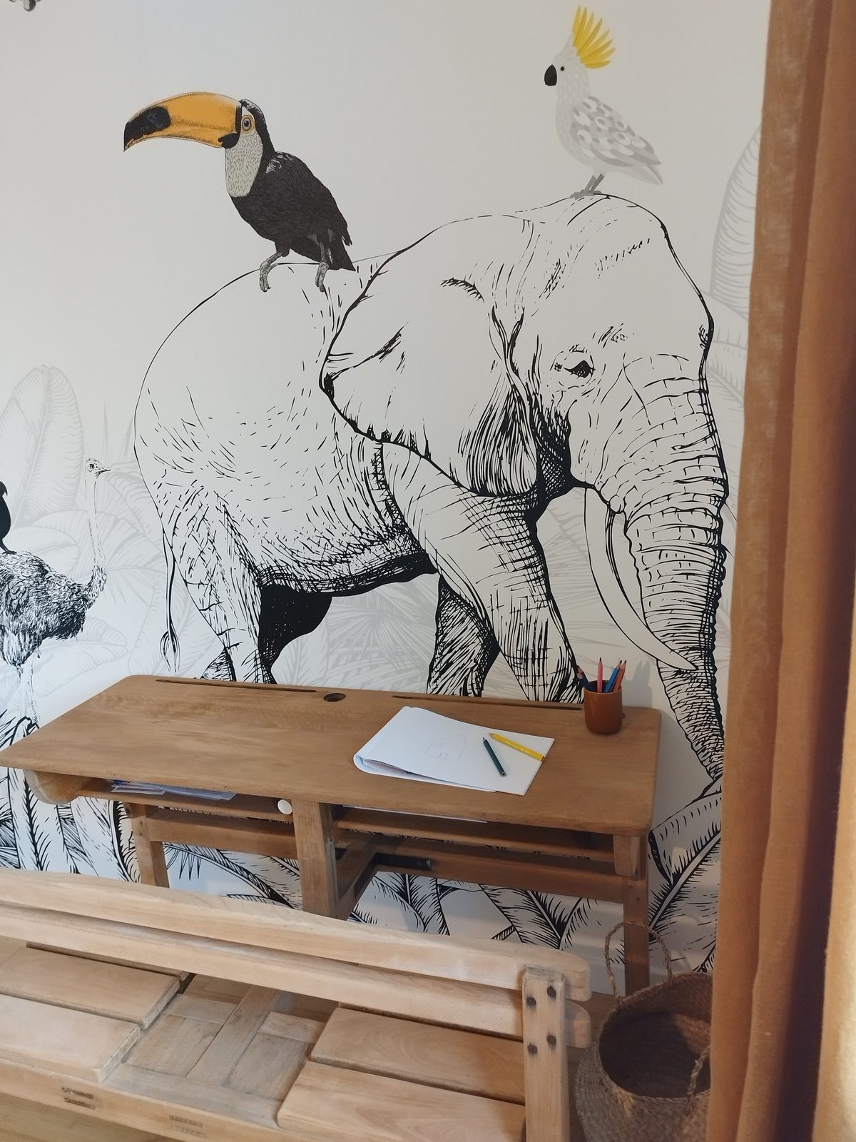Espace enfants avec bureau d'écolier et fresque jungle